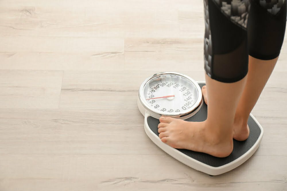 woman standing on a scale weighing herself